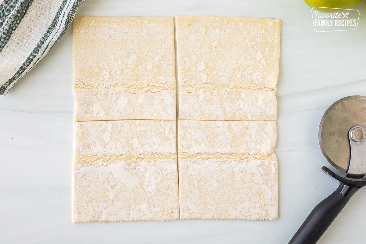 Cut puff pastry next to pizza cutter.