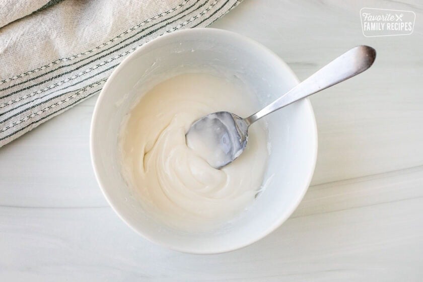 Bowl of white icing and a spoon.