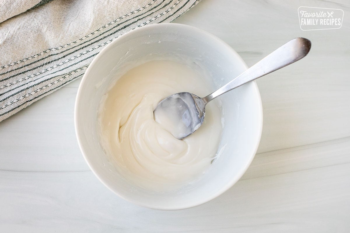 Bowl of white icing and a spoon.