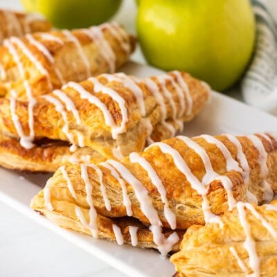 Apple Turnovers with icing on a tray.