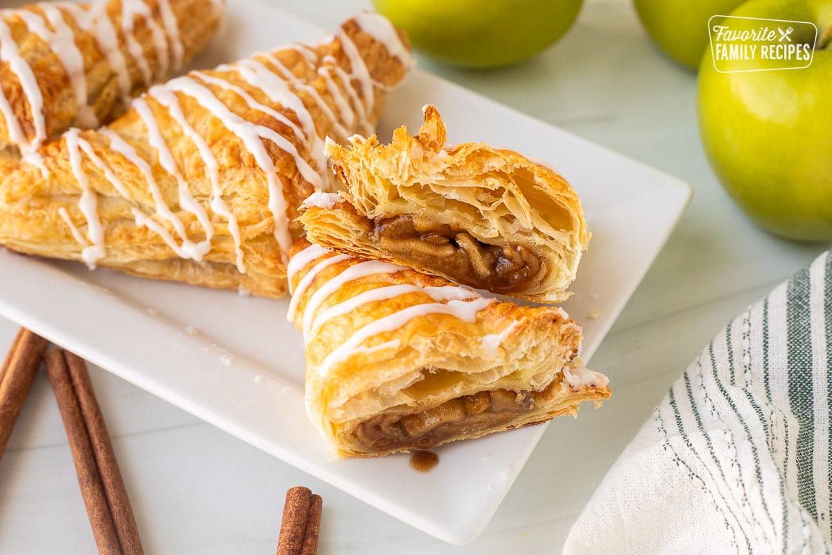 Apple Turnover cut in half with icing on a tray.