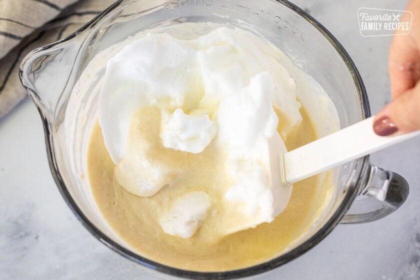 Folding egg whites into batter with a spatula.