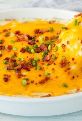 Wooden spoon scooping a serving of Loaded Mashed Potatoes.