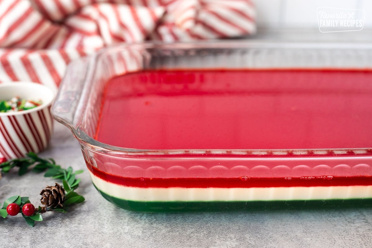 Layered Christmas Jell-O salad in a glass dish.