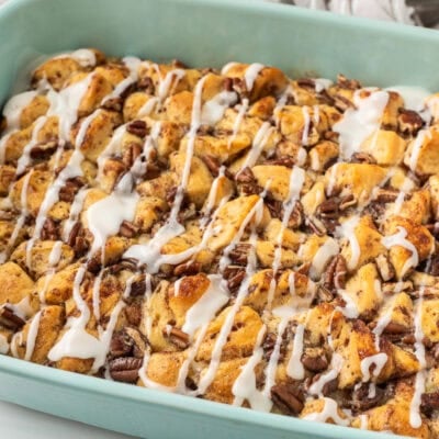 Baking dish of Cinnamon Roll Casserole with white icing on top.