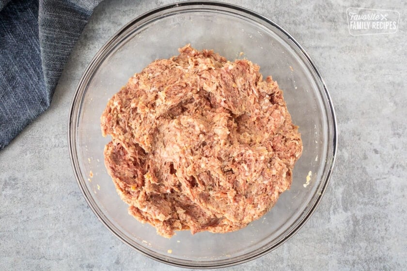 A glass bowl with well mixed ingredients to make frozen meatballs