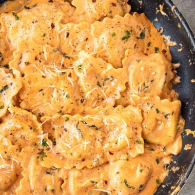 Skillet of fresh ravioli tossed in a ravioli sauce with fresh basil pepper and cheese.