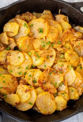 Skillet of Smothered Potatoes garnished with fresh parsley.