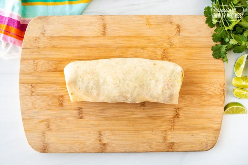 Rolled up Carne Asada burrito on a cutting board