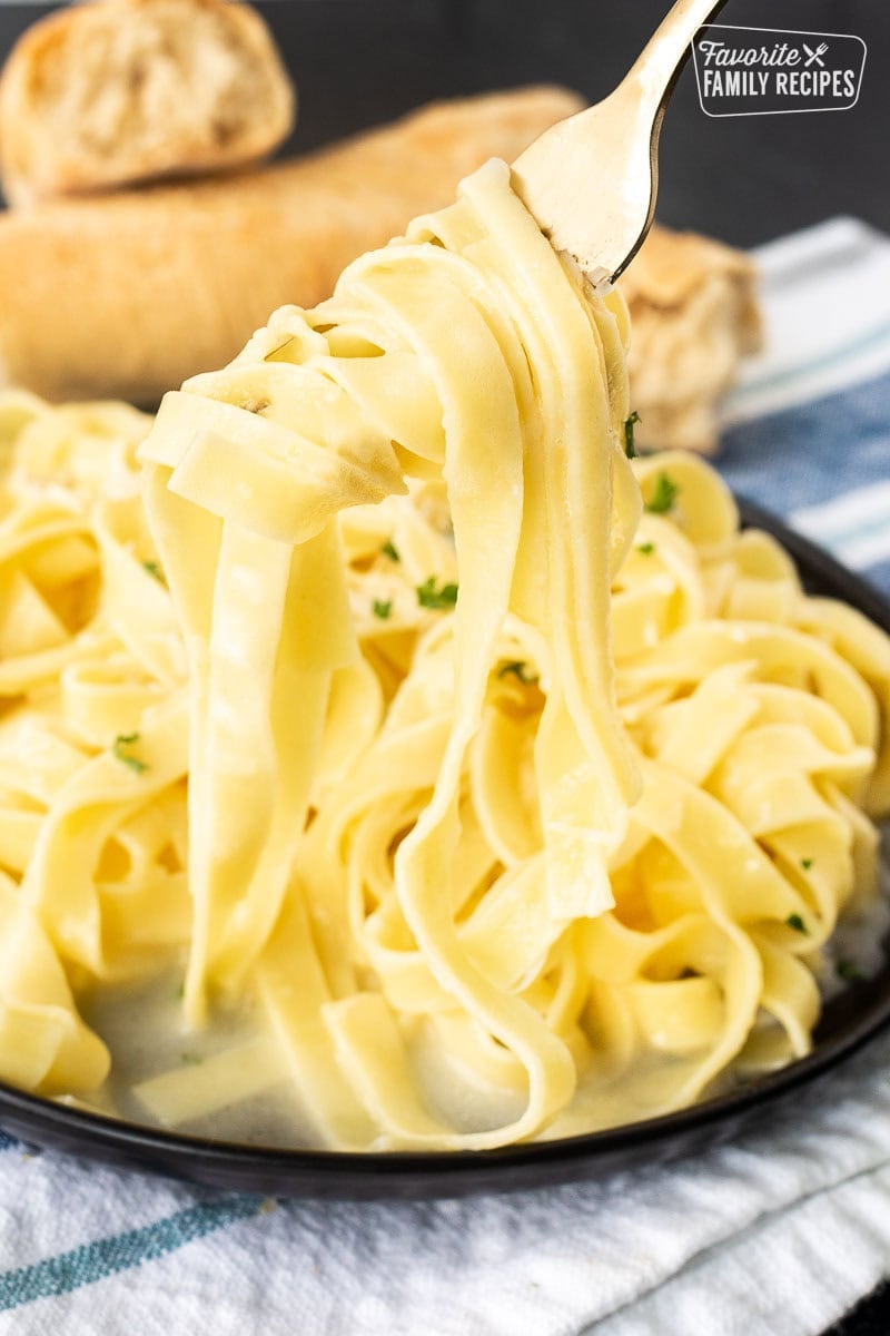 Fork twirled with Authentic Fettuccine Alfredo noodles.