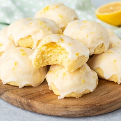 Bite taken out of a Italian lemon cookie stacked on other cookies.