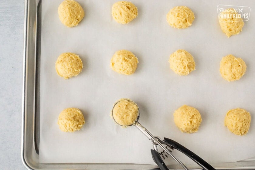 Baking sheet with scooped out balls of Italian lemon cookie dough with a cookie scoop.