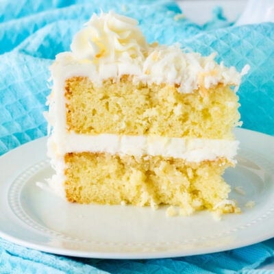 Close up of coconut cream cake with coconut frosting slice.