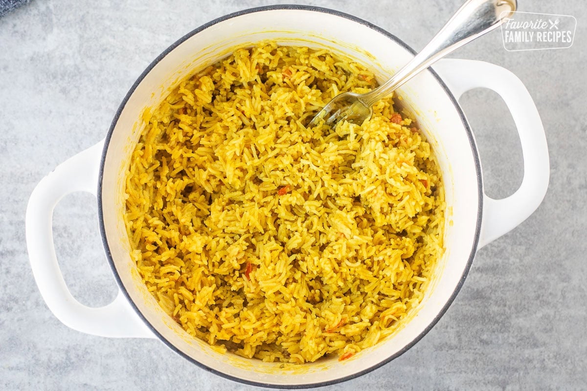 Fluffing coconut rice with a fork.