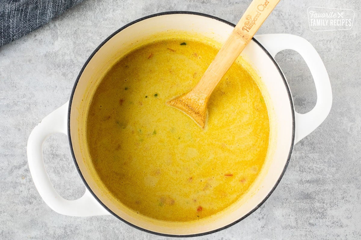 Mixing broth into rice with a wooden spoon.