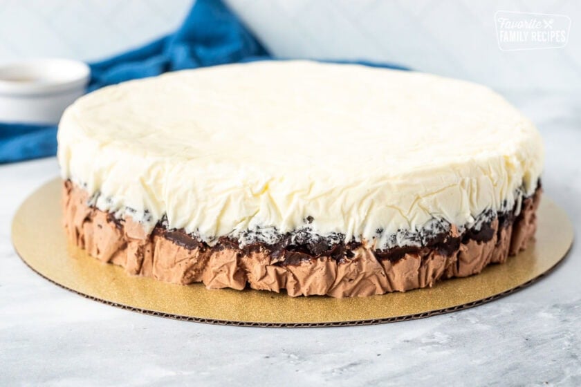 Frozen Ice Cream cake taken out of the springform pan and placed on a board.