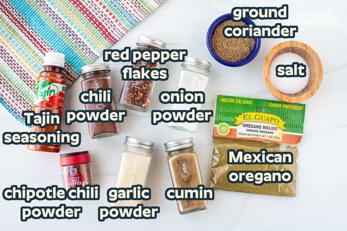 Ingredients to make Carne Asada seasoning including garlic powder, onion powder, cumin, oregano, salt, coriander, red pepper flakes, chili powder, chipotle chili Pepper powder and Tajin.