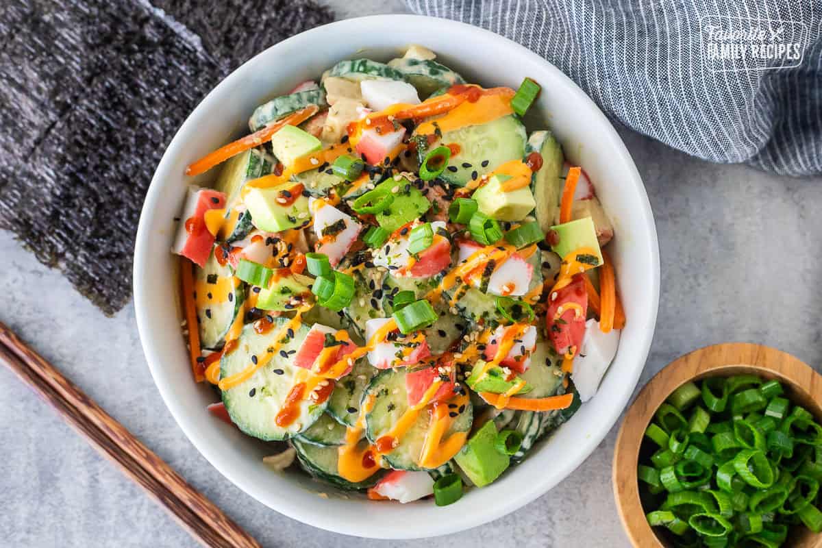 California Roll Cucumber Salad with sliced cucumbers, cut imitation crab, avocados, carrot, green onion, spicy mayo and sriracha.