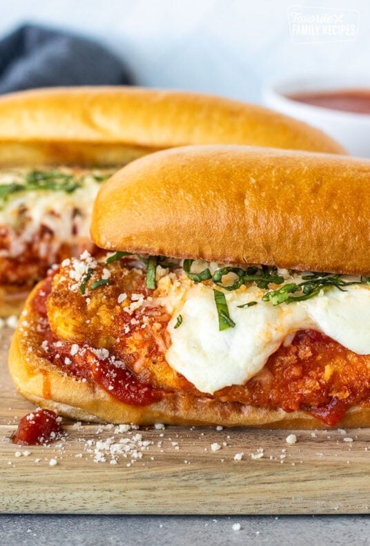 Chicken Parmesan Sandwiches with marinara, melted mozzarella cheeses and fresh basil for garnish.