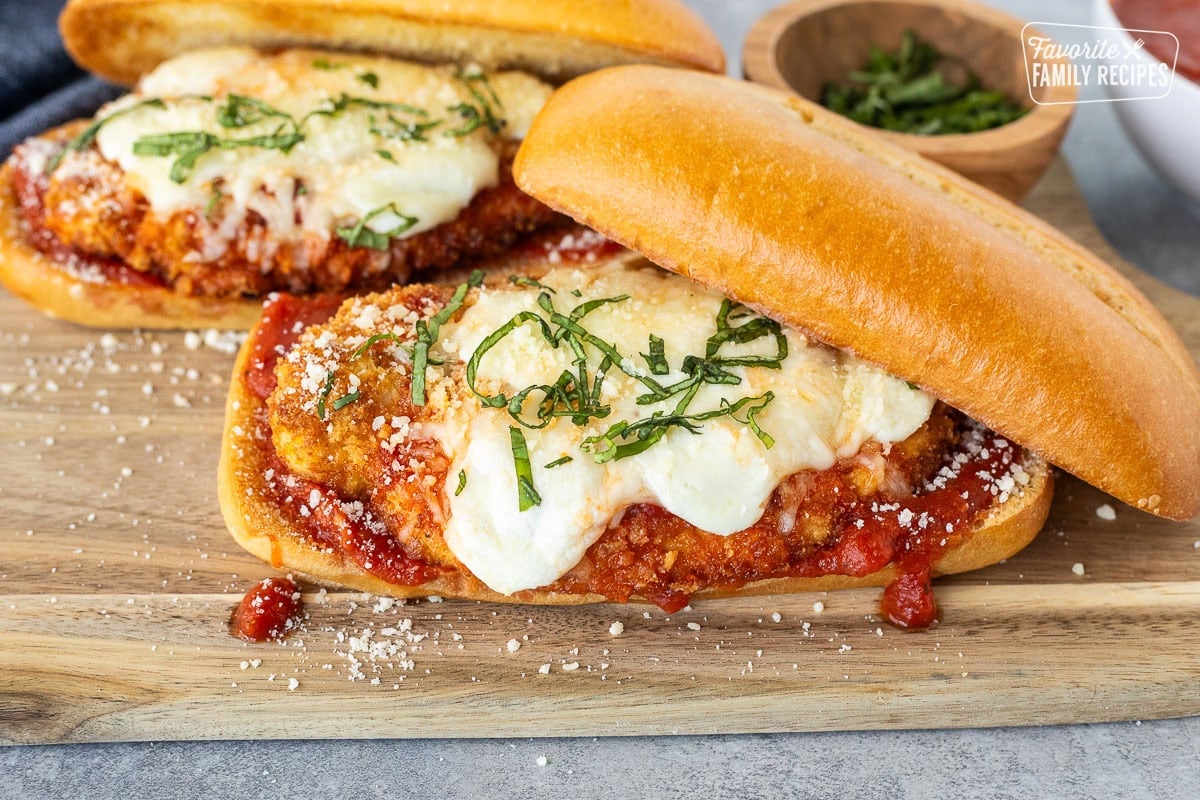 Chicken Parmesan Sandwiches with marinara, melted mozzarella cheeses and fresh basil for garnish.