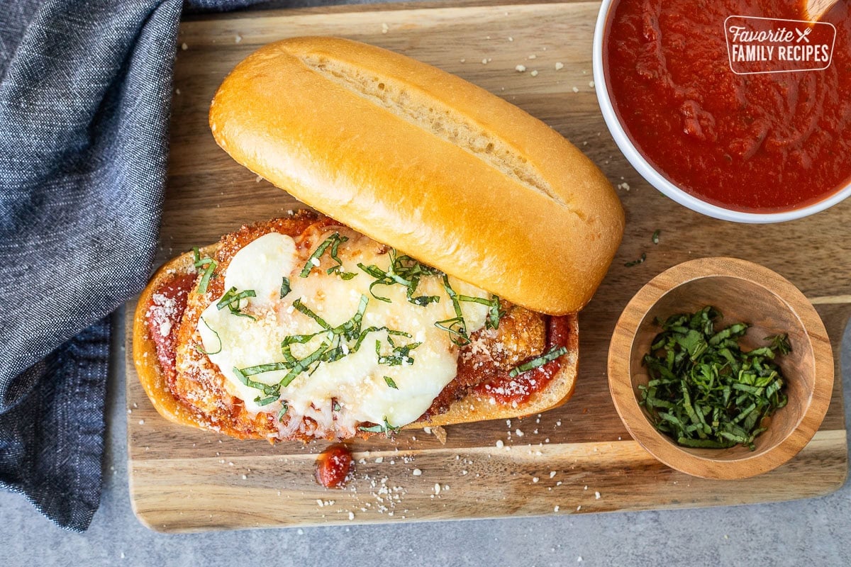 Chicken Parmesan Sandwiches with marinara, melted mozzarella cheeses and fresh basil for garnish.
