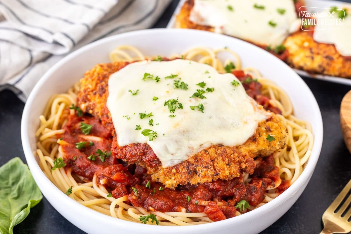 Chicken Parmesan with homemade marinara sauce, spaghetti noodles, melted mozzarella cheese and parsley.