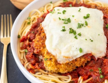 Chicken Parmesan with homemade marinara sauce, spaghetti noodles, melted mozzarella cheese and parsley.