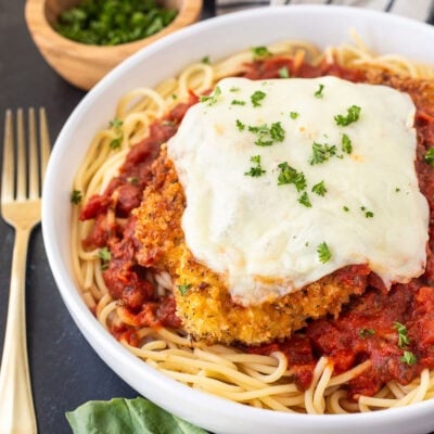 Chicken Parmesan with homemade marinara sauce, spaghetti noodles, melted mozzarella cheese and parsley.