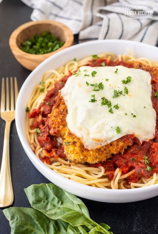 Chicken Parmesan with homemade marinara sauce, spaghetti noodles, melted mozzarella cheese and parsley.