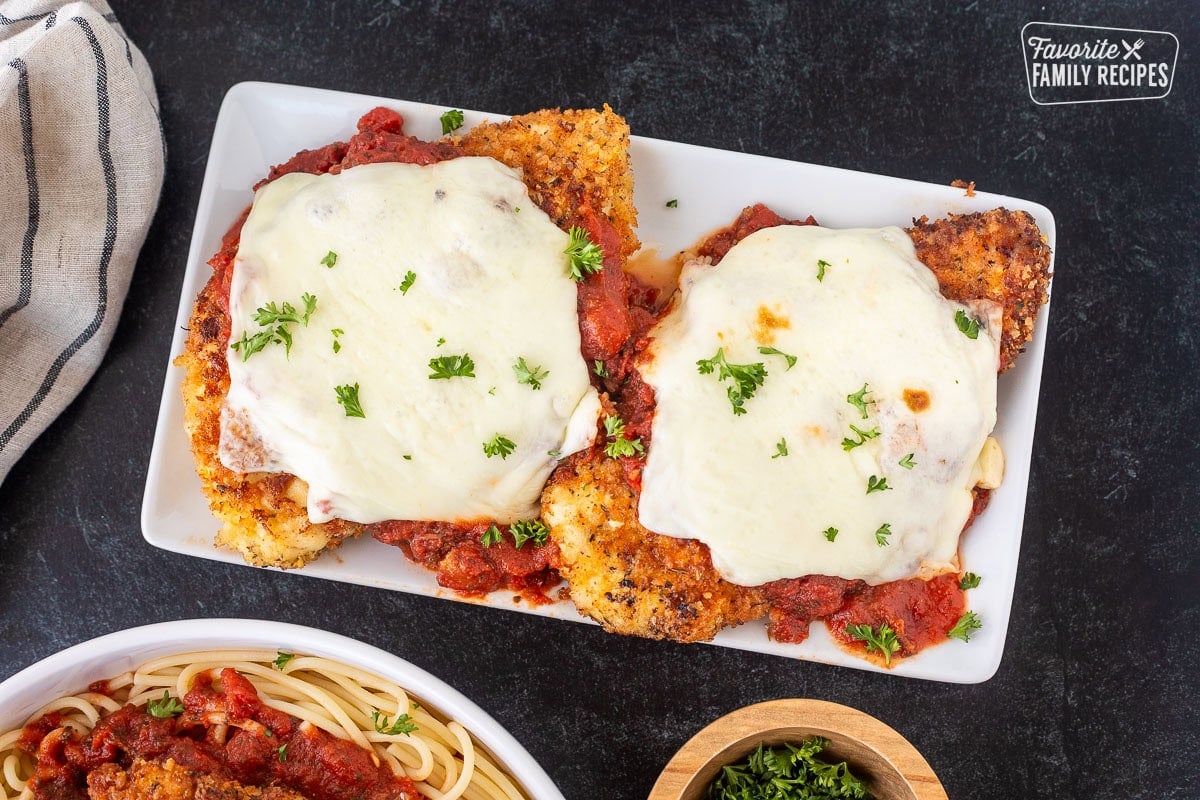 Two Chicken Parmesans with homemade marinara and melted mozzarella cheese.