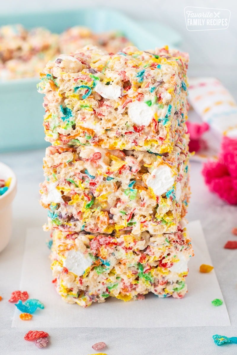 Fruity pebbles rice crispy treats cut into squares and stocked on top of each other.
