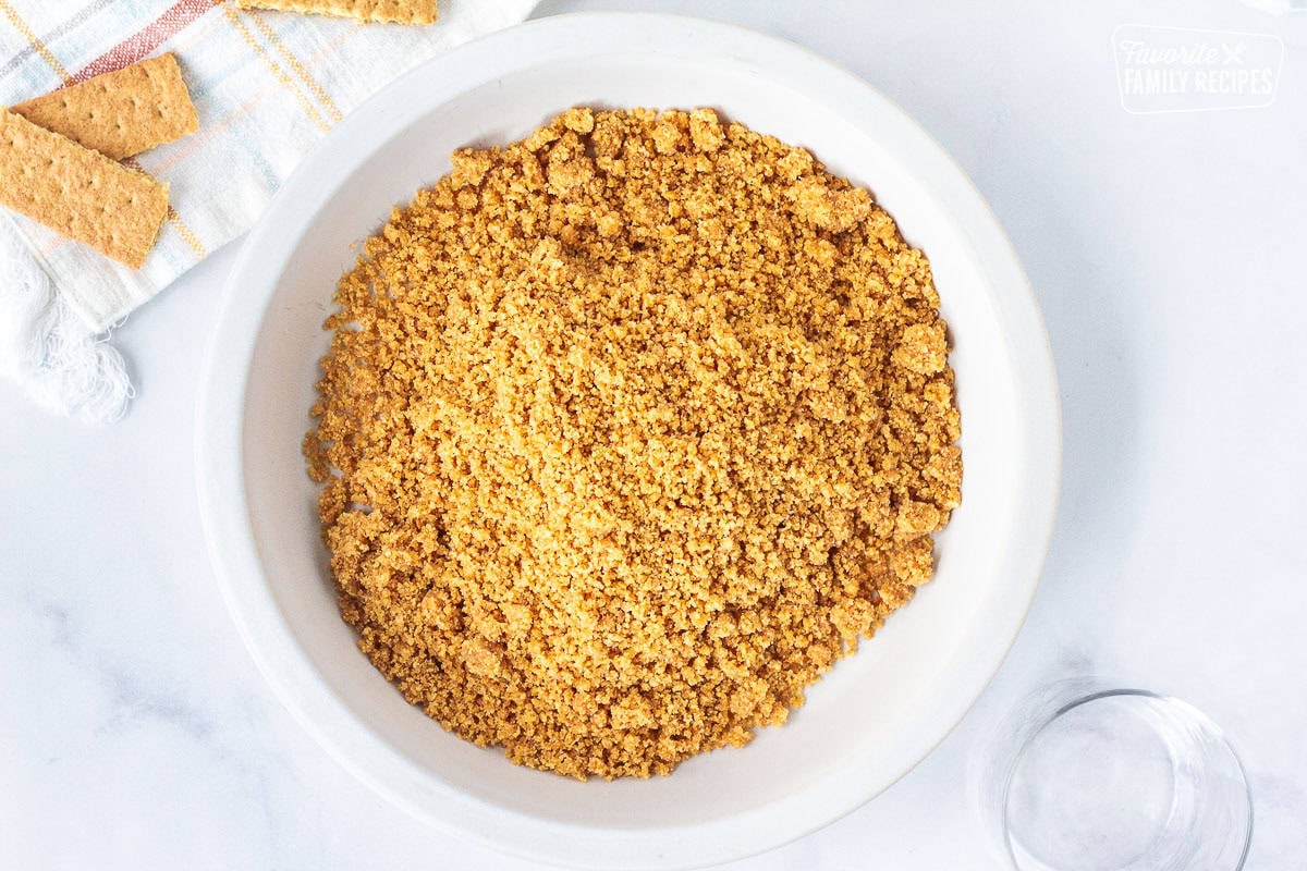 Graham cracker crust mixture in a pie plate.