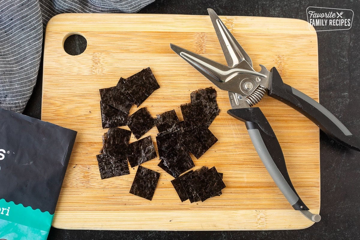 Chopped Nori with kitchen shears on a cutting board.
