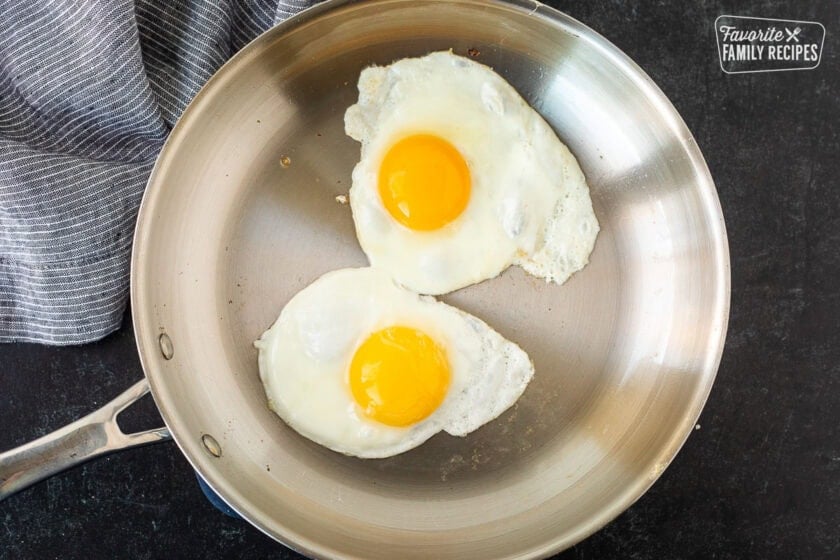 Two eggs sunny side up in a skillet.