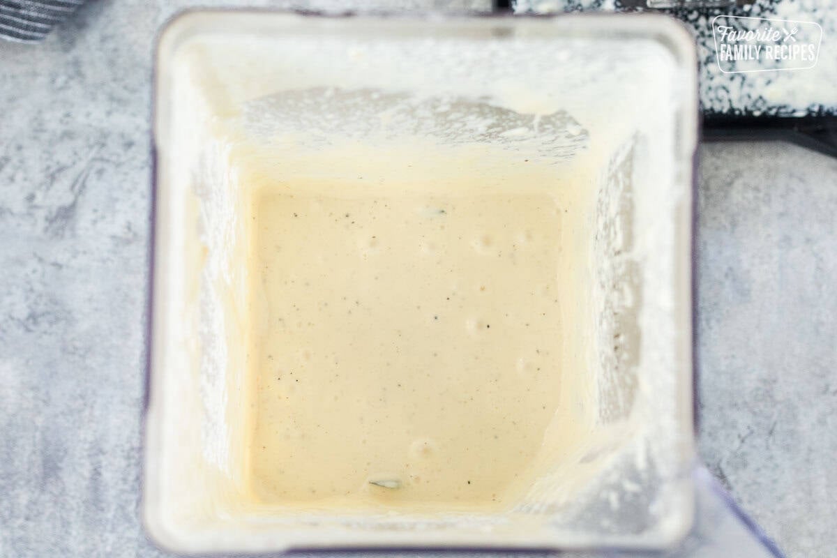 Blender with blended mayo, dijon, lemon juice and apple cider vinegar.