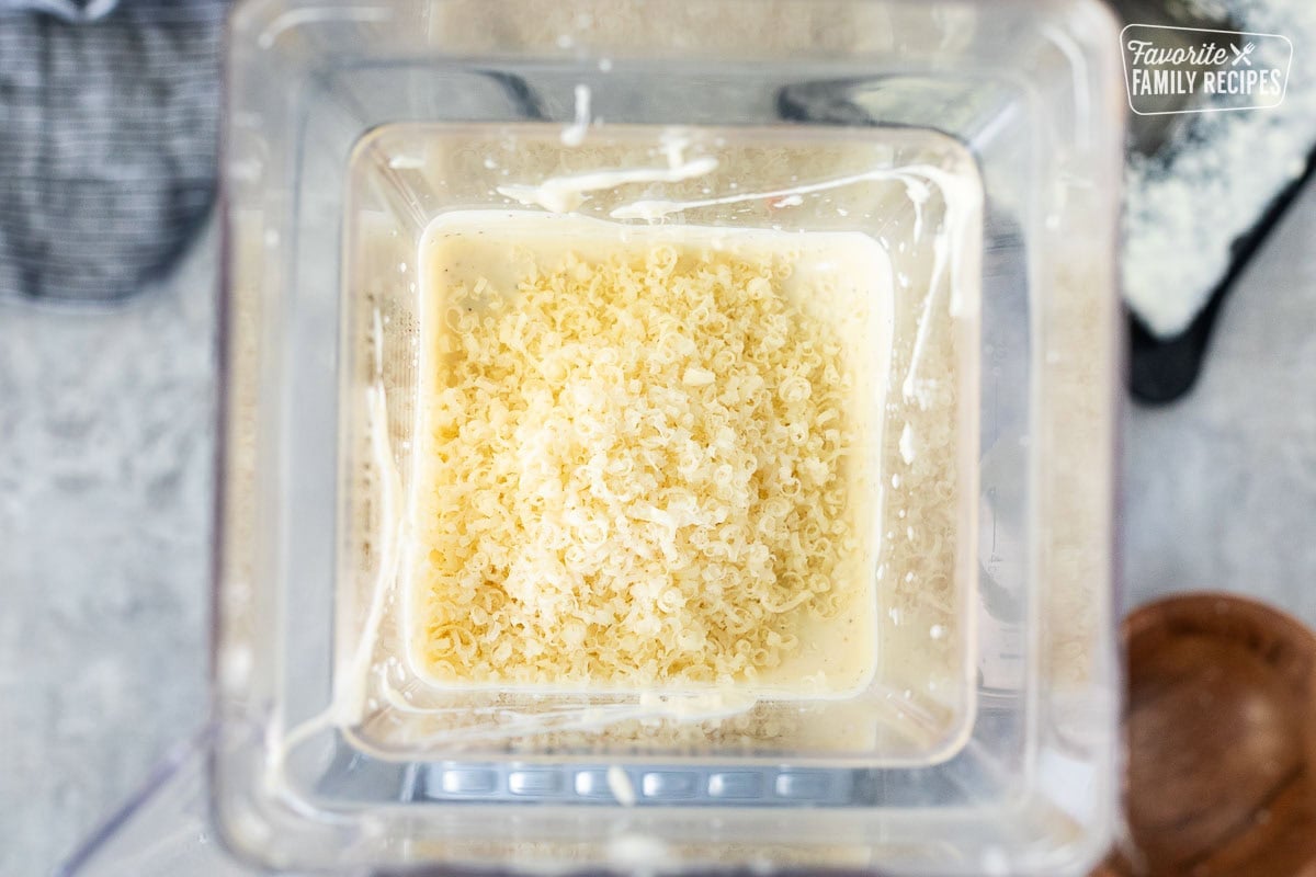 Grated cheese added to Caesar Salad dressing in a blender.
