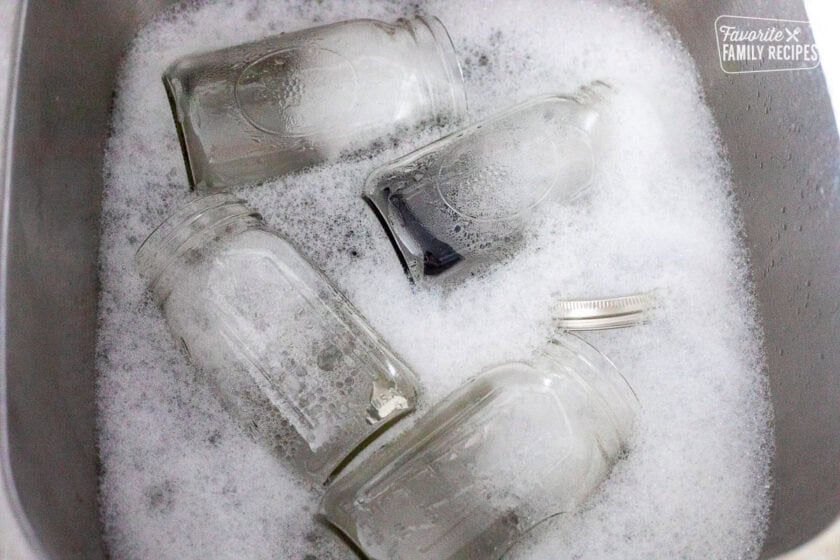 Quart size canning jars in warm soapy water.