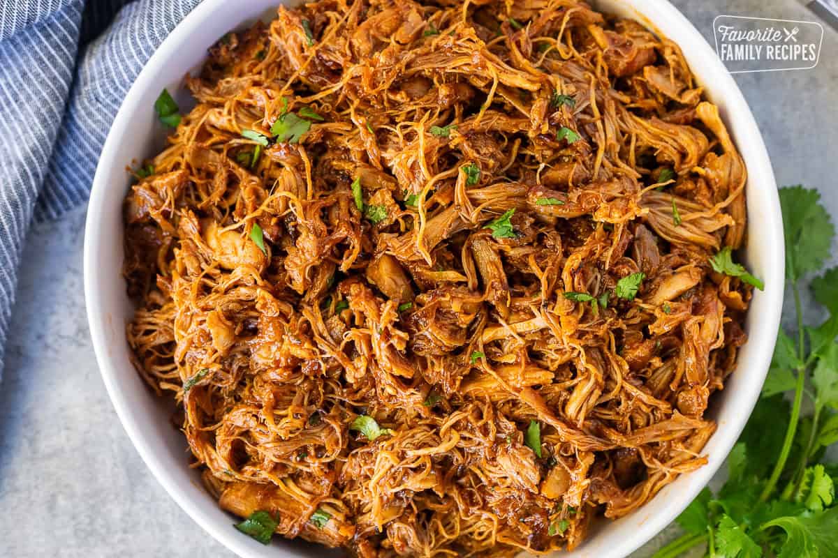 Instant Pot BBQ Chicken in a bowl with cilantro.