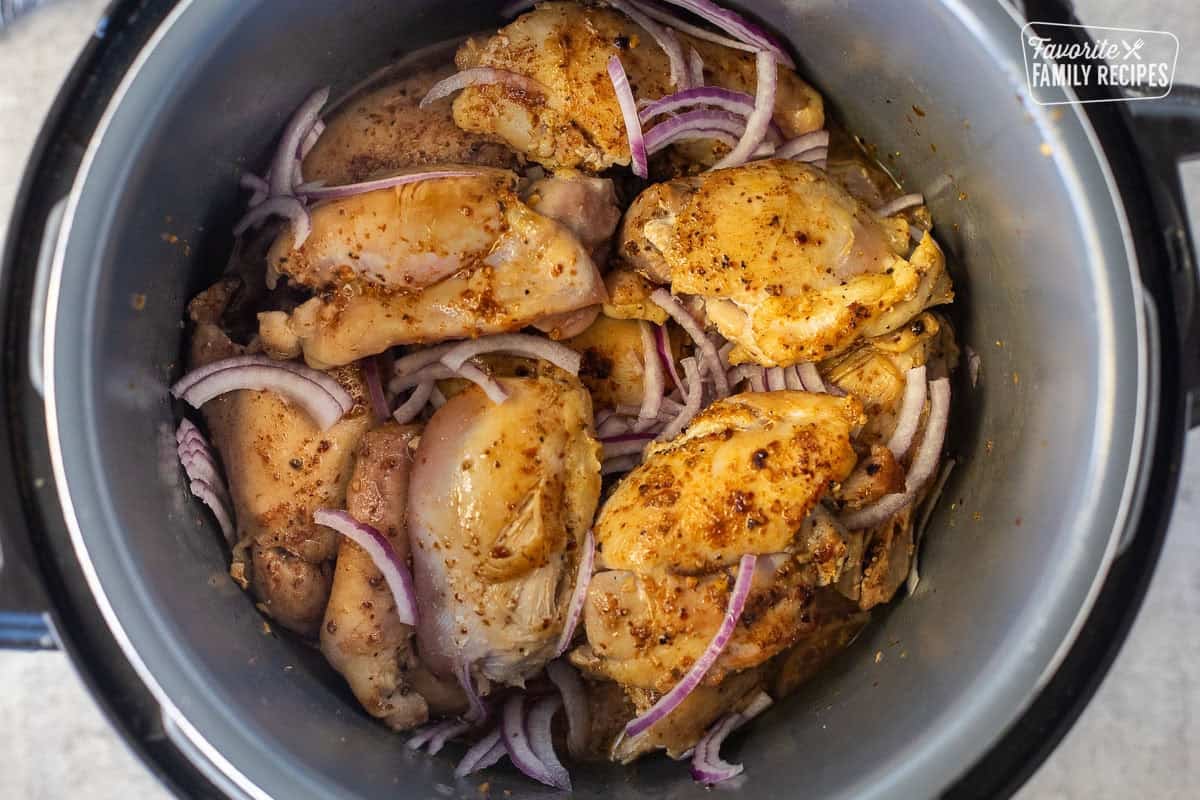 Seared chicken thighs with red onion in an instant pot.