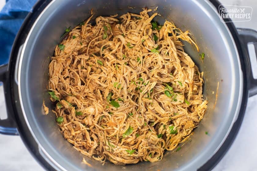 Instant pot with Chicken taco filling with cilantro and lime juice.