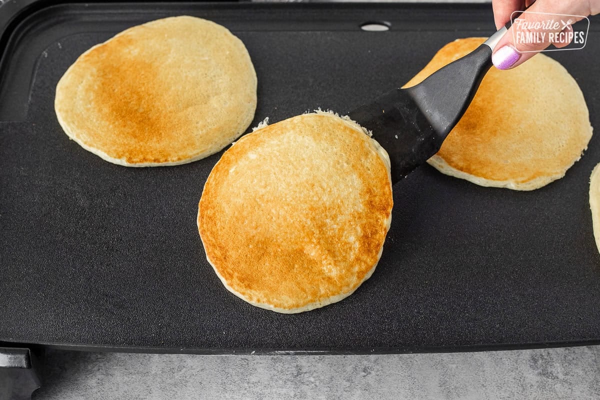 Flipping pancakes from scratch with a spatula.