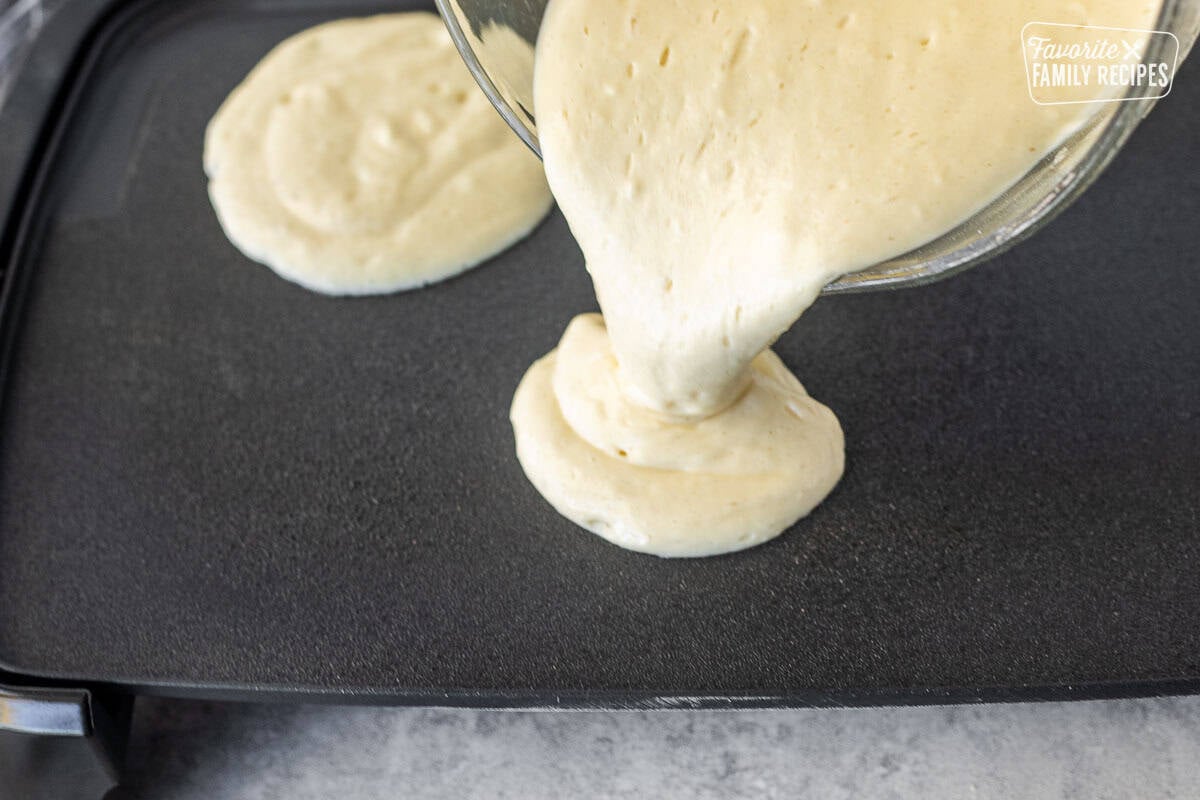 Pouring pancakes onto griddle.