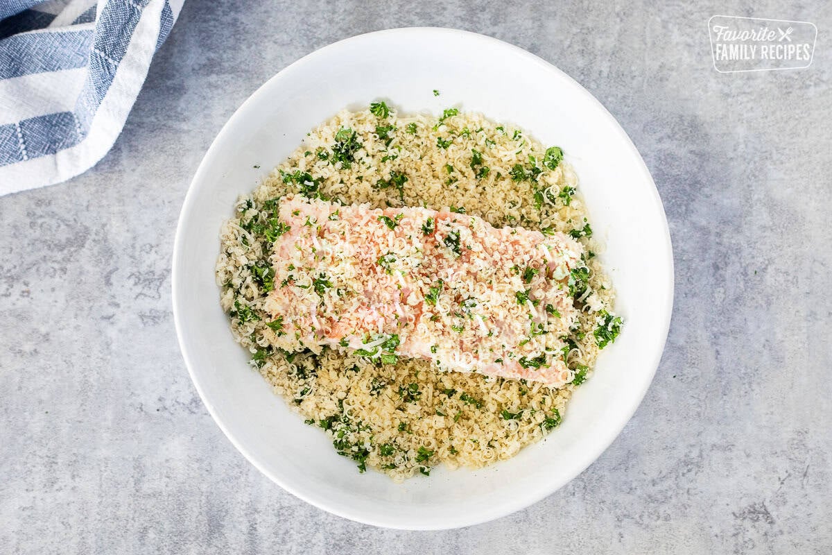Piece of salmon coated in panko mixture in a bowl.