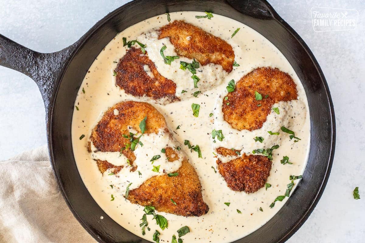 Pan Fried Chicken in Basil Cream Sauce and garnished with fresh basil.