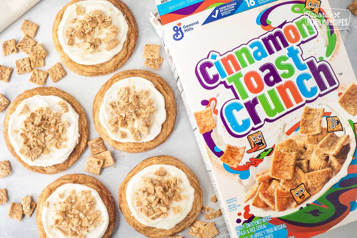 Box of Cinnamon Toast Crunch cereal next to frosted Cinnamon Toast Crunch cookies.