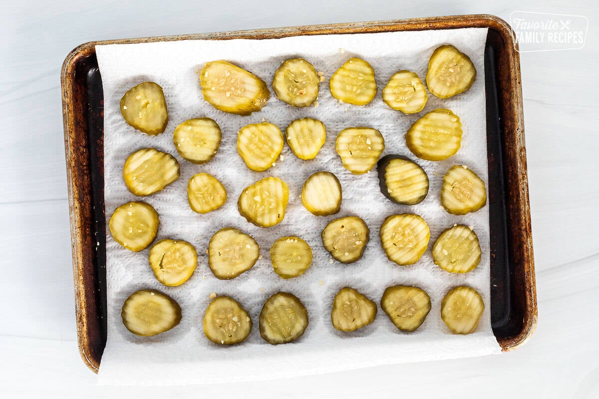 Pickle chips over a paper towel on a sheet pan.
