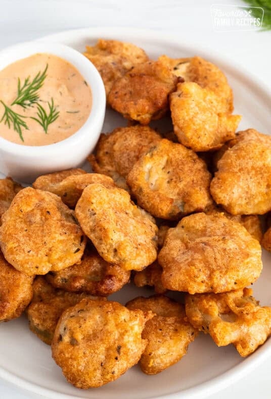 Fried pickles on plate with a small bowl of Sriracha dill dipping sauce.