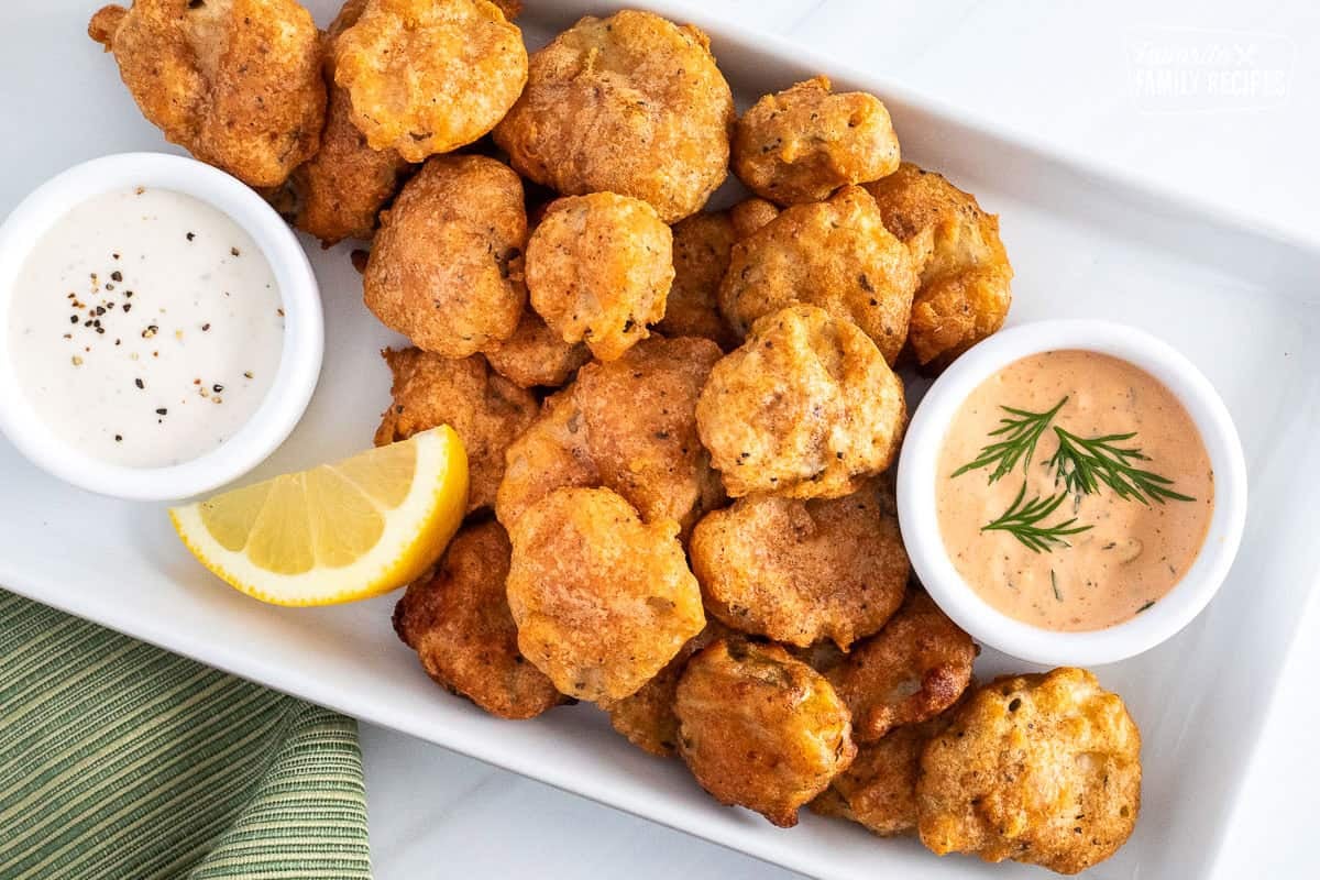 Fried pickles on platter with small bowls of Sriracha dill dipping sauce and ranch sauce.