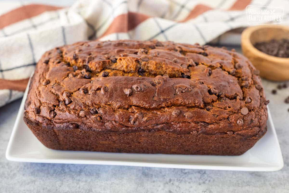 Loaf of pumpkin chocolate chip bread on a rectangular platter.