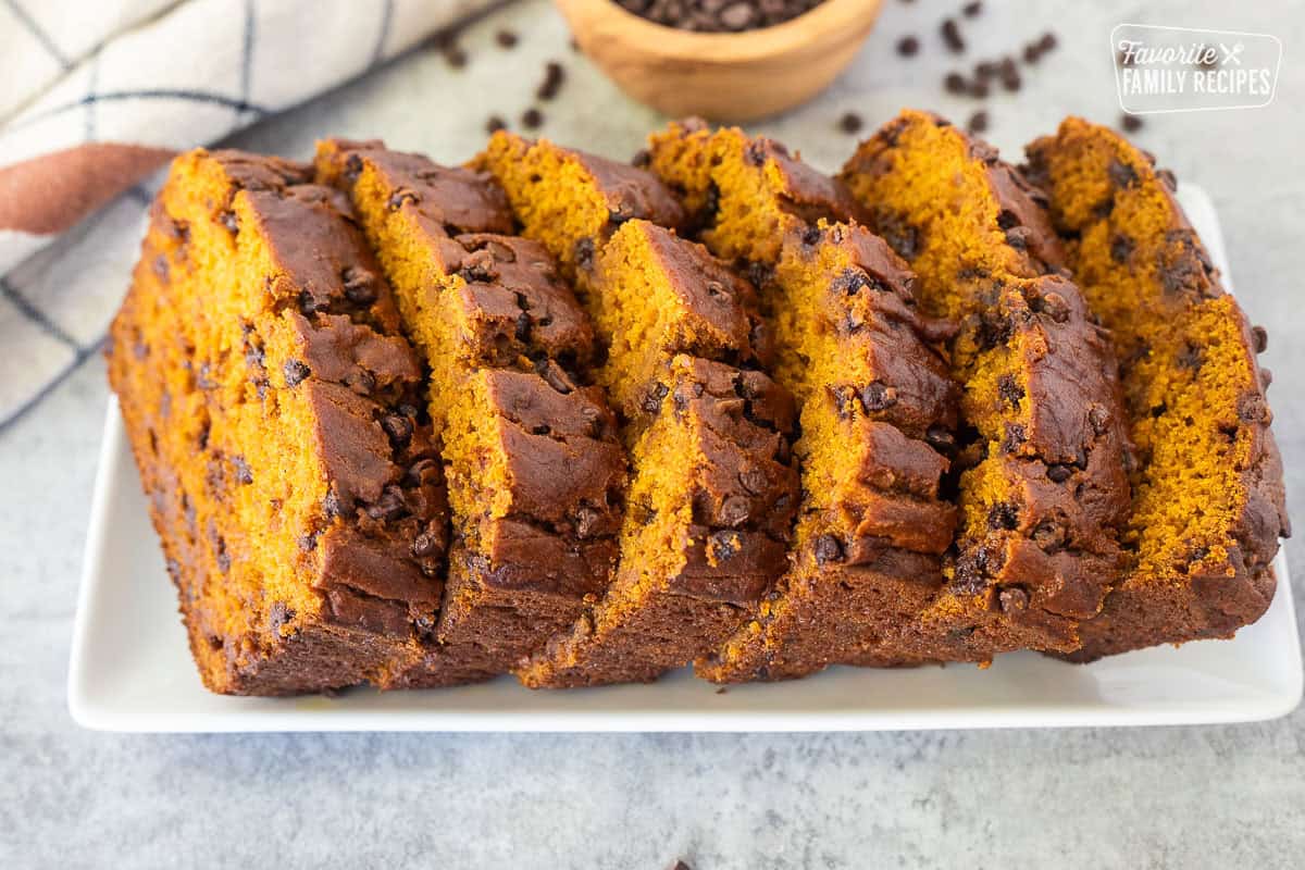 Six slices of pumpkin chocolate chip bread fanned out on a platter.